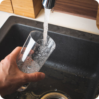 A glass of fresh water under water water tap